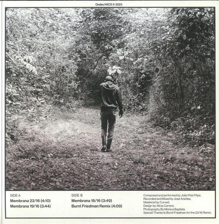 Black and white album cover showing a person in a hoodie walking through a forest path.