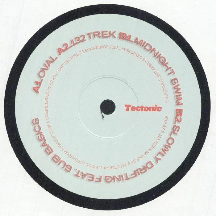 Close-up of Tectonic record label on vinyl with tracklist in red text, pale background.