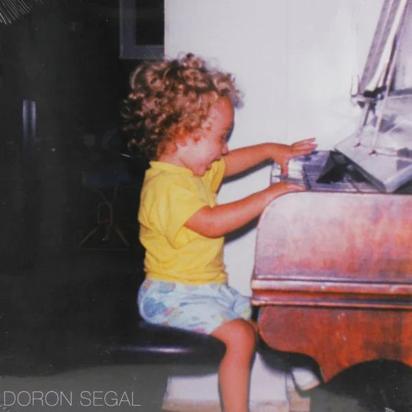 Young child with curly hair playing piano, vintage photo, music album cover