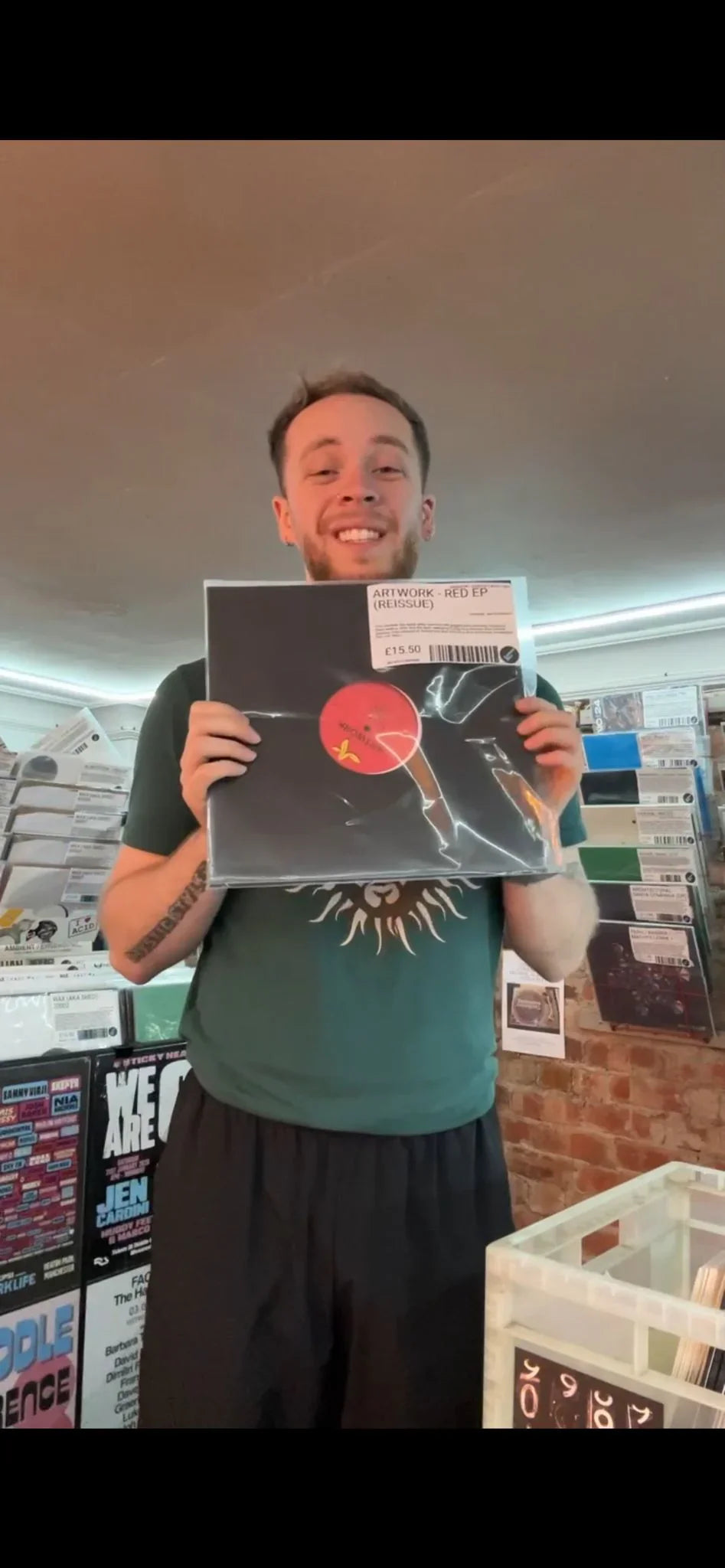 Smiling person in record store holding Artwork Red EP 12-inch vinyl reissue
