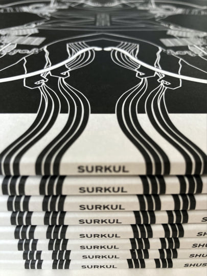 Stacked Surkul magazines with black and white abstract wavy line cover art