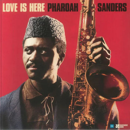 Album cover showing a man holding a saxophone on a red background, text reads 'Love Is Here Pharoah Sanders'.