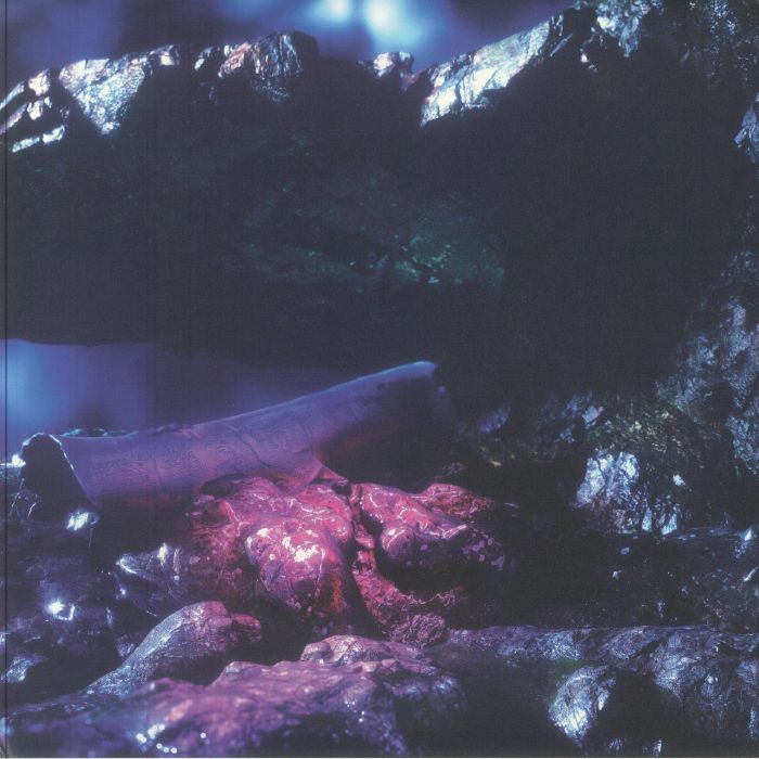 Close-up of iridescent dark purple and black rocks with glowing red mineral veins in low light