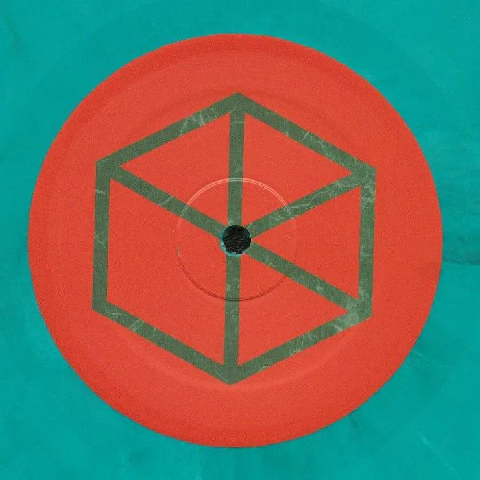 Teal and red vinyl record with geometric cube pattern on the label