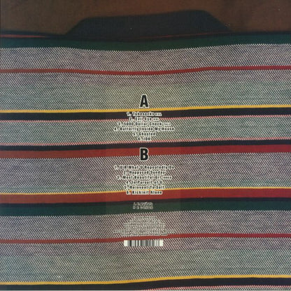 Back cover of a music album listing tracks on sides A and B over a colorful striped woven fabric background