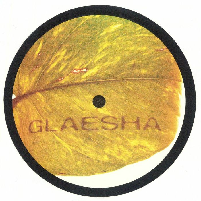 Close-up of yellow-green leaf with GLAESHA text printed on it, round black border