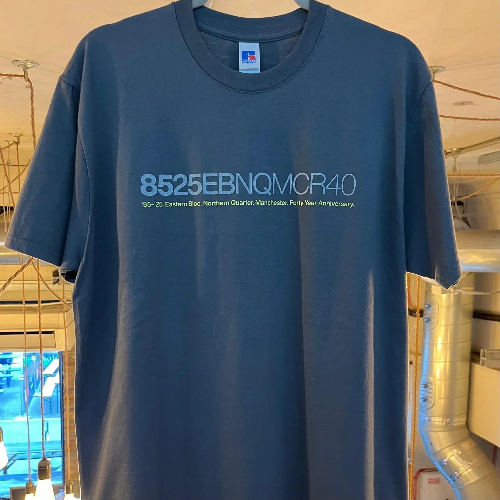 Navy blue t-shirt with white and blue anniversary graphic text celebrating Northern Quarter Manchester.